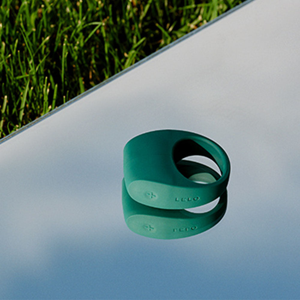 Close-up of a green lelo tor 2 couples ring, a love ring vibrator.