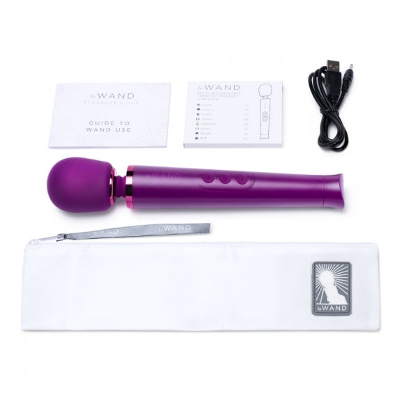 A petite, dark cherry Le Wand vibrating massager, rechargeable for targeted sensual massage.