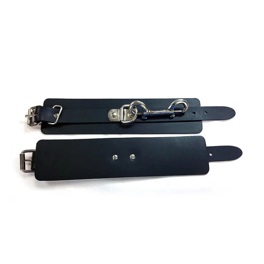 Pair of black rubber wrist cuffs, part of Rouge Garments' restraints collection.