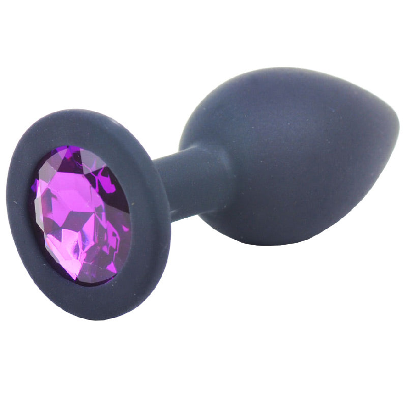 Small black silicone butt plug with a sparkly jewelled base, close-up view.