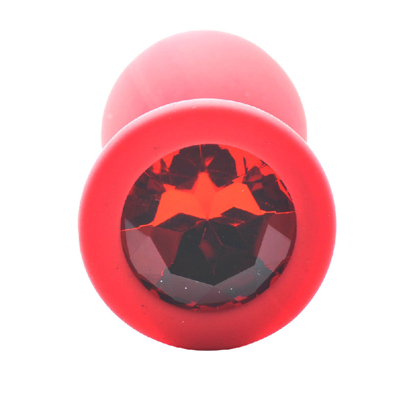 Large red silicone butt plug with a faceted, jewel-like base, for anal play.