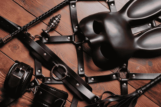 Image of kinky sex toys and bondage from LoveKinx on a wooden surface.
