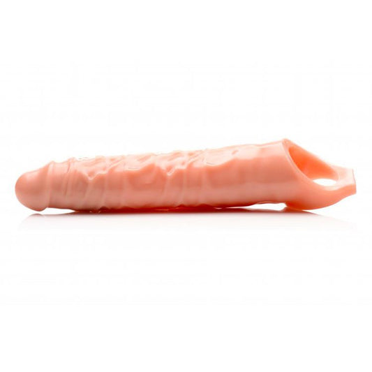 Close-up of a flesh-toned, textured penis extender sleeve, approximately three inches long.