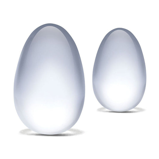 A set of two clear, smooth glass yoni eggs, for pelvic floor exercise.