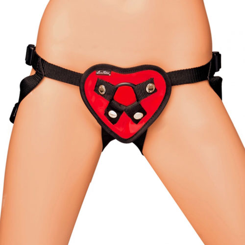 Lux Fetish red heart strap-on harness with adjustable straps, metal hardware and a glossy finish.