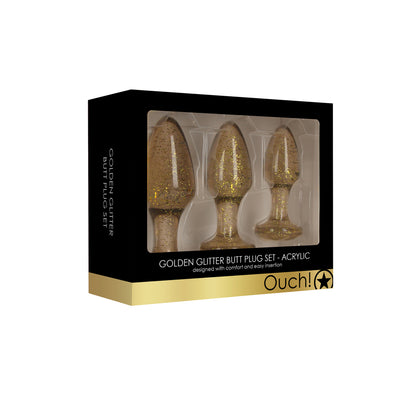 Set of three golden glitter acrylic butt plugs from Shots Toys, different sizes.