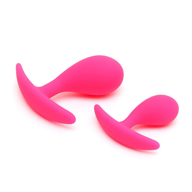 Two pink, smooth silicone butt plugs from rimba, a graduated set for anal play.