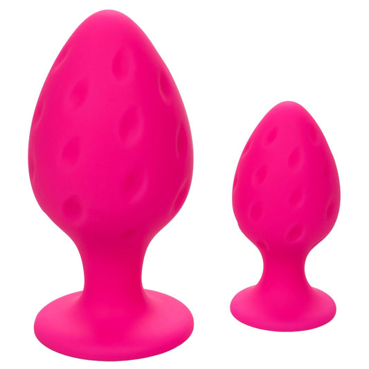 A pair of pink, smooth silicone butt plugs, shaped for comfortable anal play.
