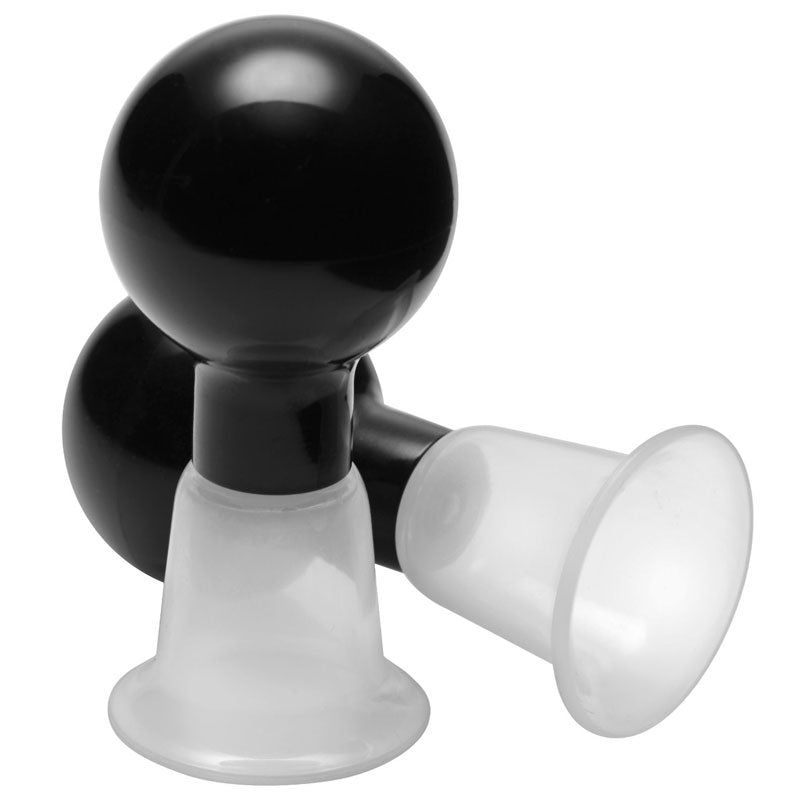 Close-up of clear plastic nipple pumps designed to temporarily enhance and boost nipple size for women.