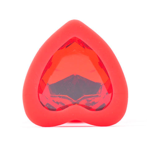 Red silicone butt plug with a small heart-shaped clear diamond-effect base, close-up.