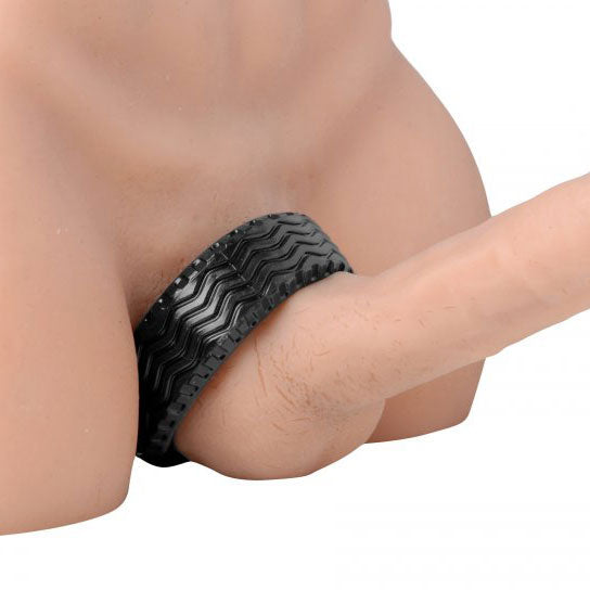 Close-up of a black, textured 'tread ultimate' cock ring; ribbed design; love ring.